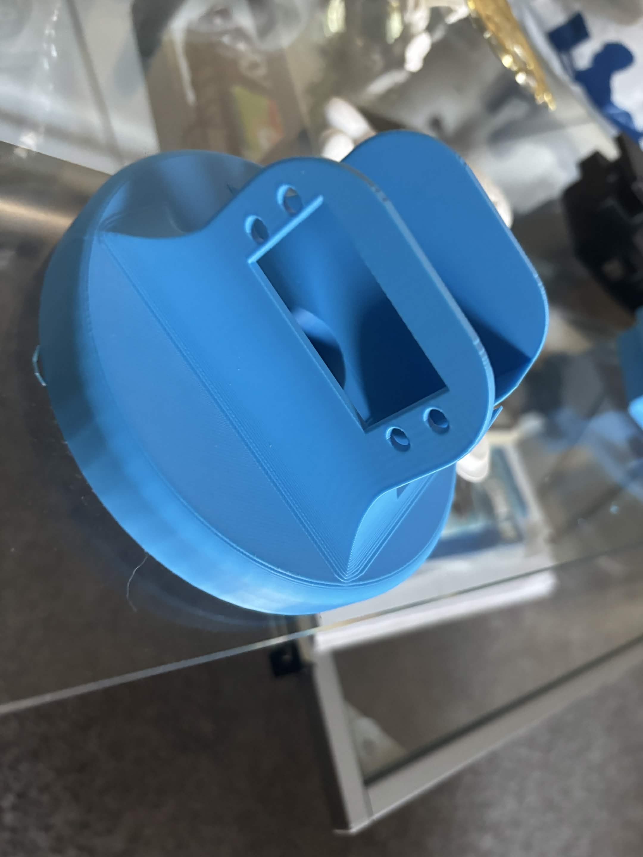 Blue circular 3D-printed robotic-arm base piece with a rectangular servo opening and mounting holes