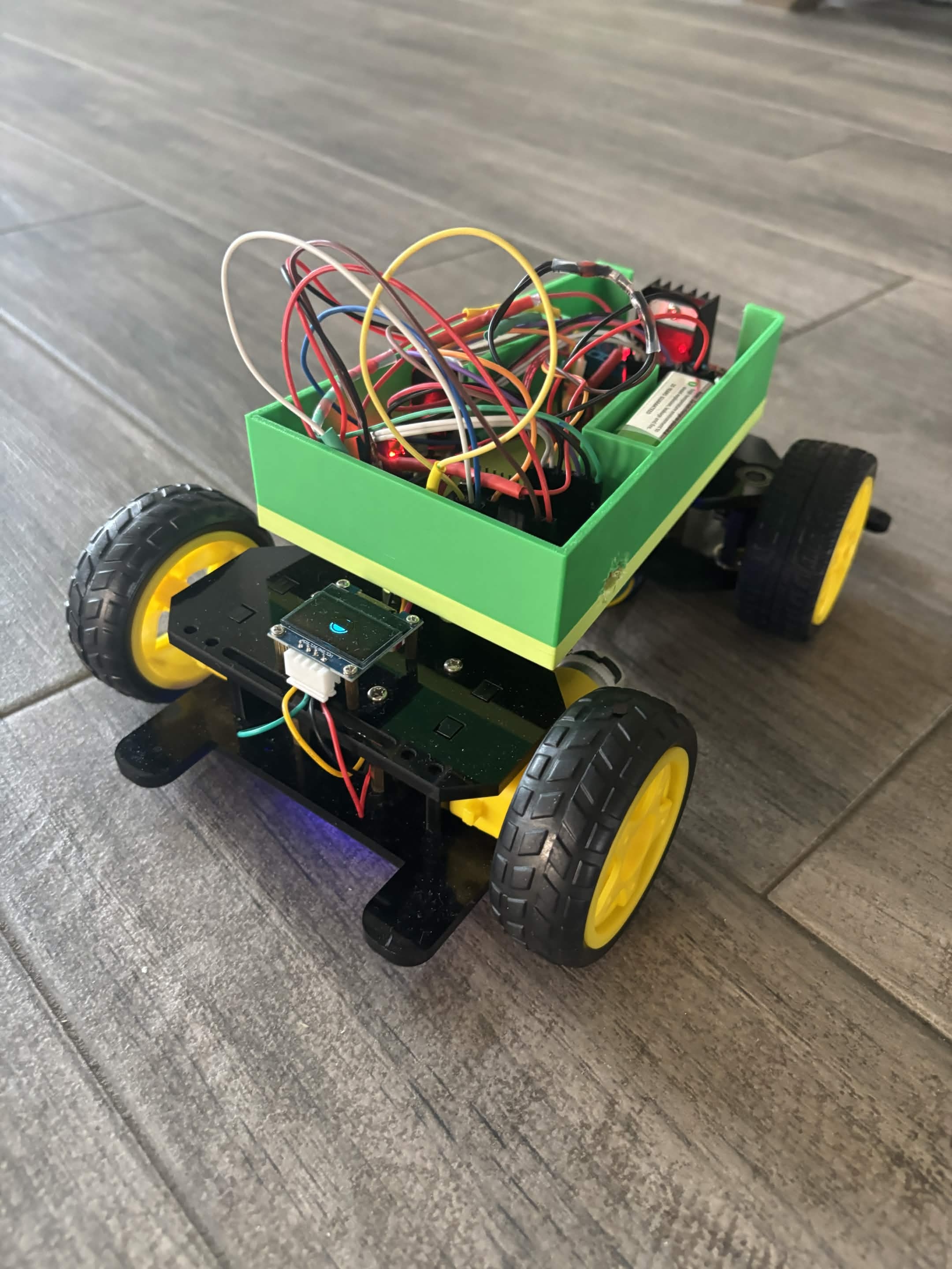 Steven's green ESP32 RC car viewed from the front with its wiring and electronics exposed